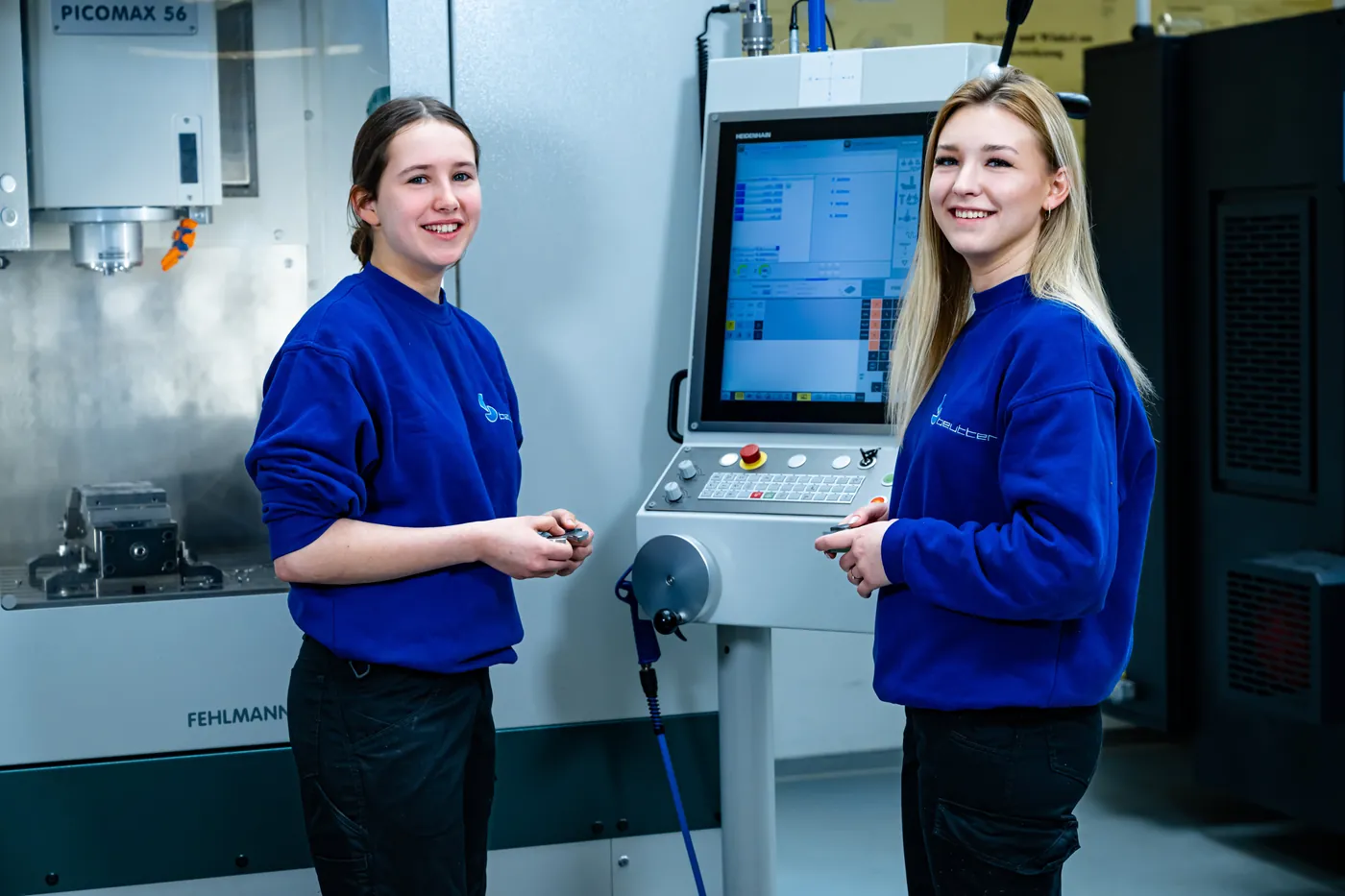 Zwei Auszubildende von BEUTTER an der Steuerung einer Fehlmann Picomax 56 CNC-Fräsmaschine