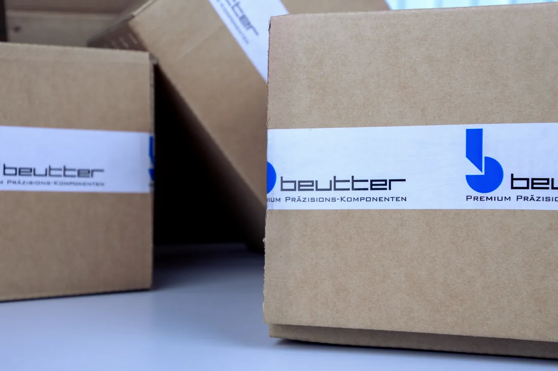 Versandfertige BEUTTER-Kartons mit Logo-Klebeband, bereit zur Auslieferung